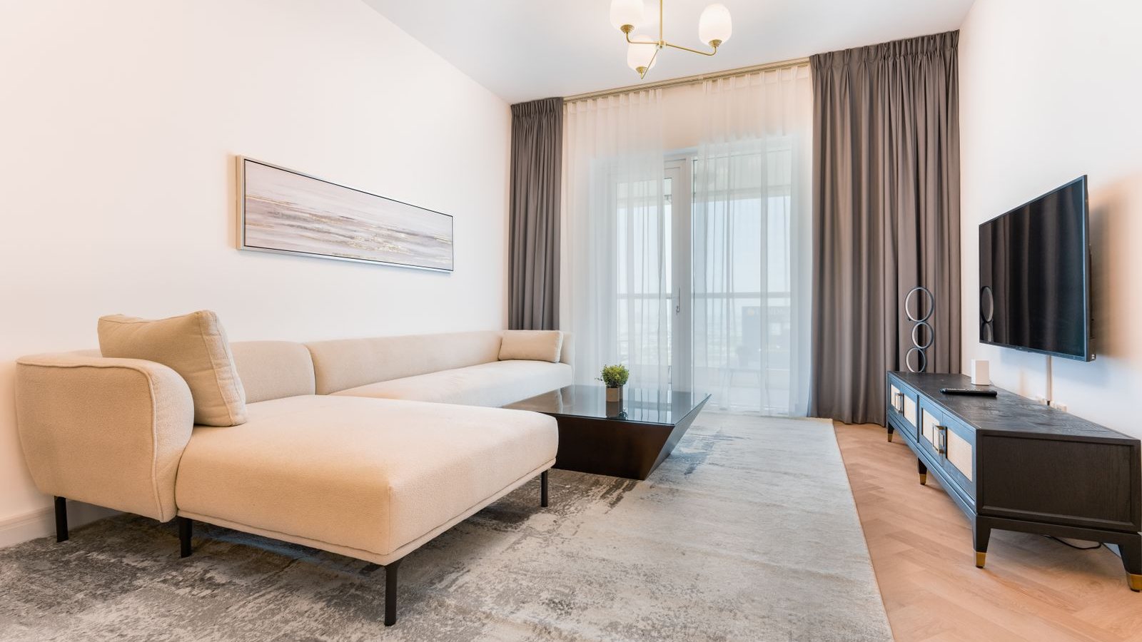 Jasny salon z dużym dywanem pod kanapą i stolikiem kawowym, z zasłonami w tle